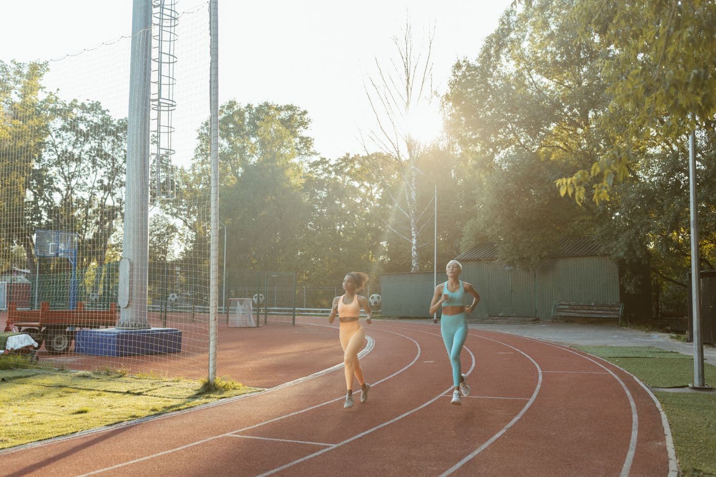 Dos mujeres corriendo juntas en una pista al aire libre